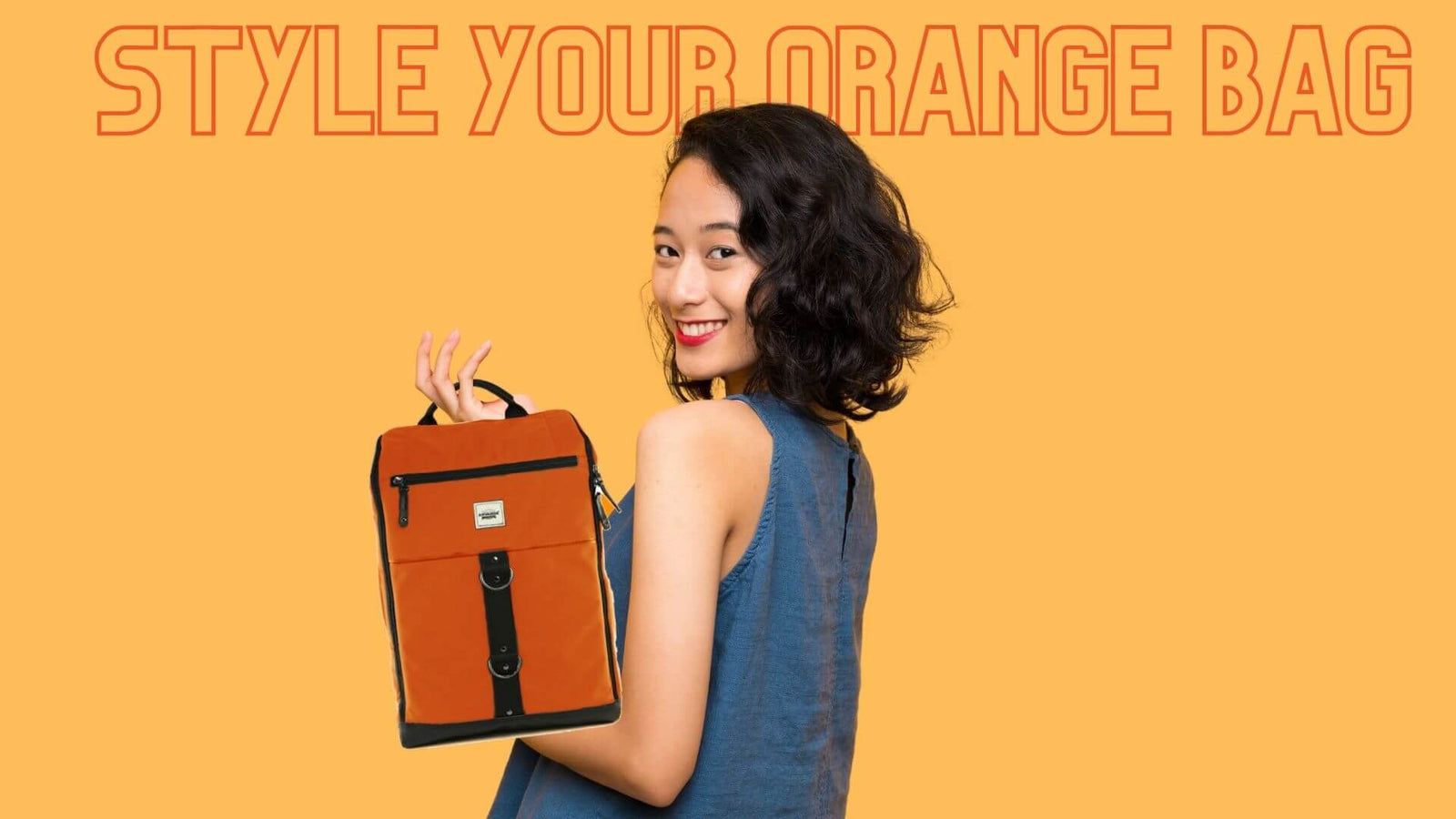 A woman carrying an orange Anvanda bag