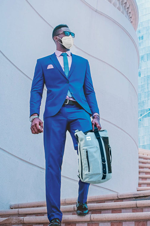 man in a suit wearing the kn95 n95 masks while holding the anvanda great freakin bag